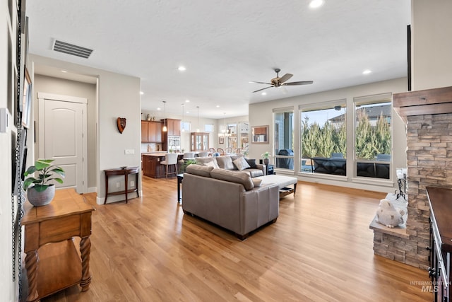 living area with visible vents, light wood-style flooring, a fireplace, recessed lighting, and ceiling fan