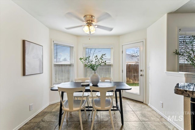 dining room with a ceiling fan and baseboards