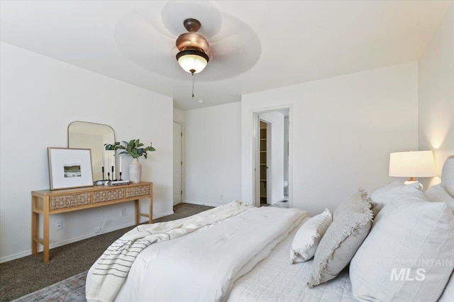 bedroom with a spacious closet, carpet flooring, ceiling fan, and baseboards