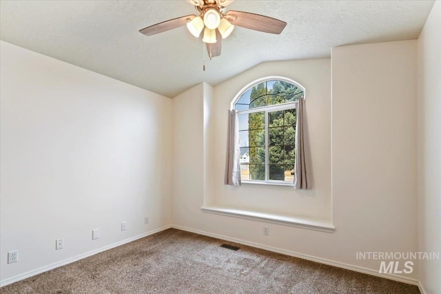 carpeted empty room featuring visible vents, a ceiling fan, a textured ceiling, baseboards, and lofted ceiling