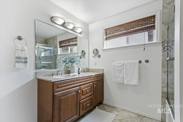 full bathroom with a sink, baseboards, a stall shower, and double vanity