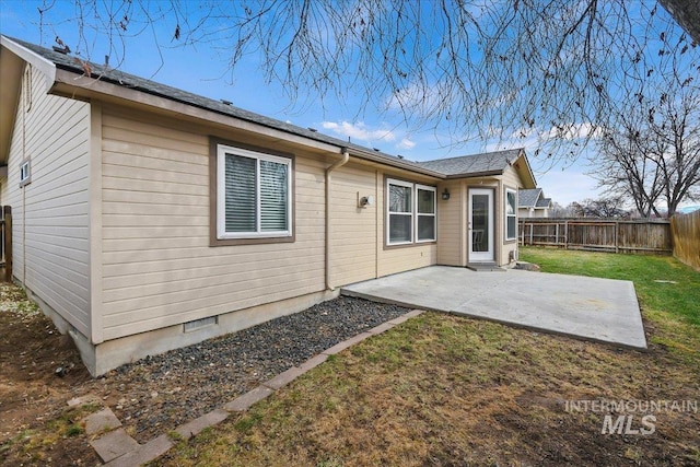 rear view of house featuring a patio area, a lawn, and a fenced backyard