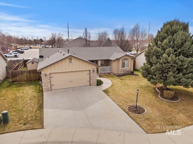 single story home with stone siding, concrete driveway, a front yard, and fence