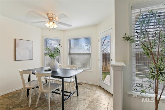 dining space with baseboards and ceiling fan