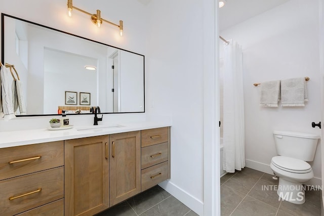 bathroom featuring tile patterned flooring, baseboards, vanity, and toilet