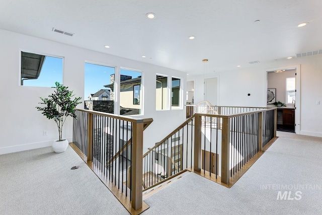 corridor featuring carpet flooring, an upstairs landing, and visible vents