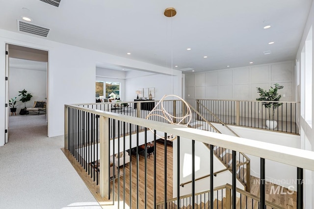 corridor with visible vents, an upstairs landing, and recessed lighting