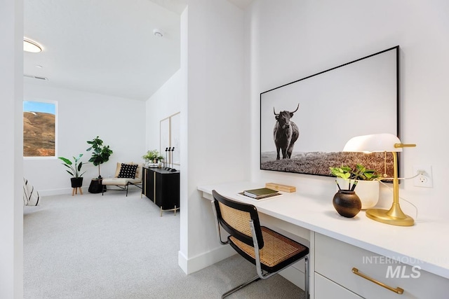 office area with light carpet, built in desk, and baseboards