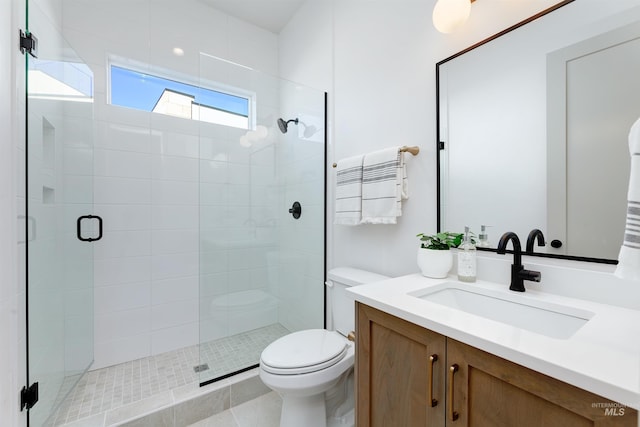 bathroom featuring toilet, a stall shower, and vanity