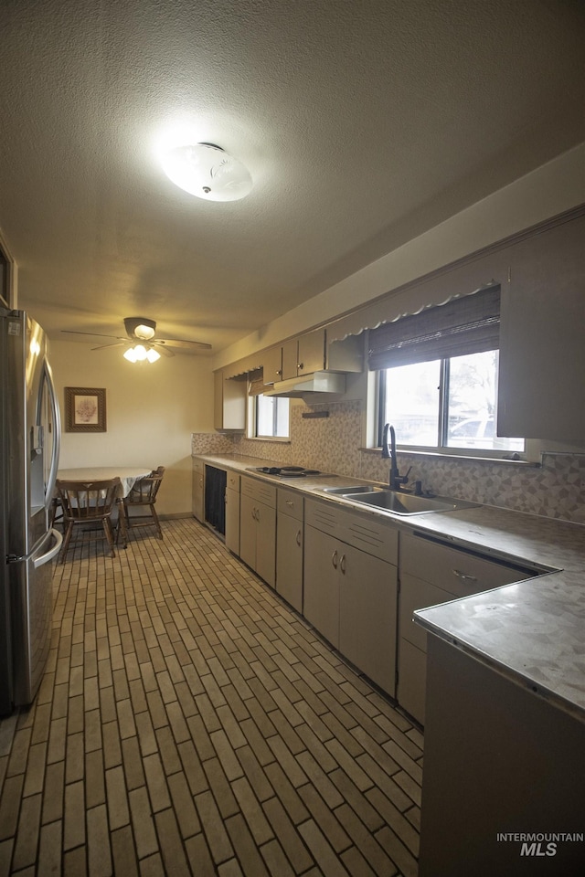104 Friendship Ln, Council, ID 83612 - kitchen featuring stainless steel appliances, brick patterned floors, ceiling fan, tasteful backsplash, and a textured ceiling