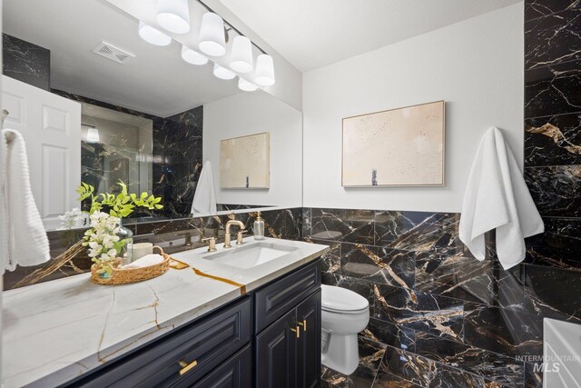1915 S Roosevelt St, Boise, ID 83705 - bathroom with tile walls, vanity, toilet, marble finish flooring, and a shower
