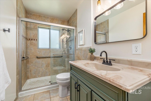 bathroom featuring vanity, toilet, an enclosed shower, and tile patterned flooring