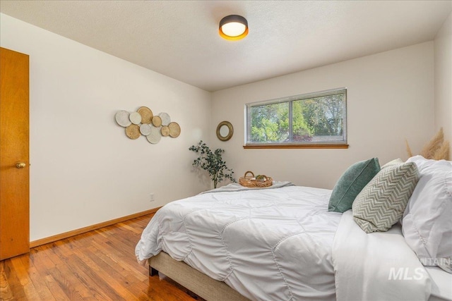 bedroom with hardwood / wood-style flooring and a textured ceiling