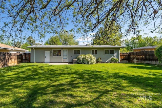 back of house with a yard and a patio area