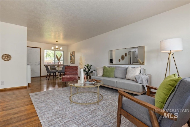 living room featuring a textured ceiling, wood-type flooring, and a chandelier