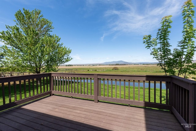 deck with a yard and a mountain view