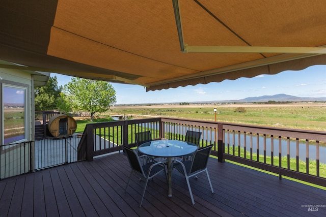 deck featuring a water and mountain view and outdoor dining space