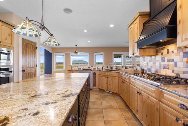kitchen featuring light stone countertops, appliances with stainless steel finishes, premium range hood, recessed lighting, and decorative backsplash