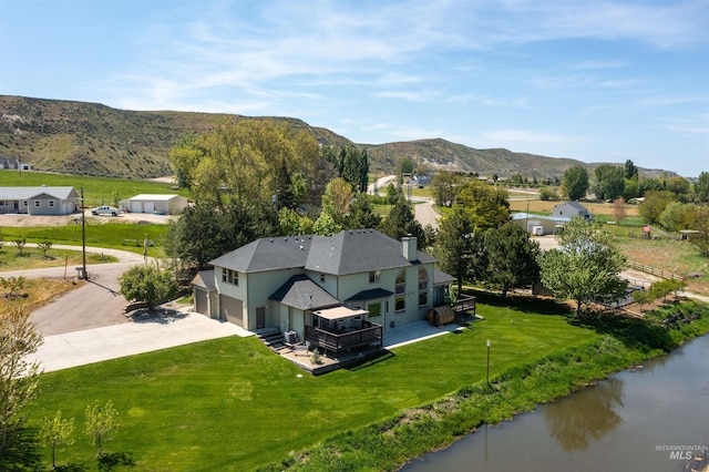 drone / aerial view featuring a water and mountain view