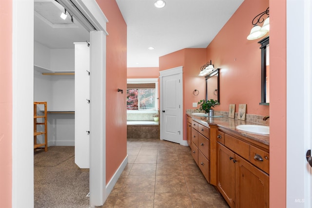full bathroom featuring double vanity, a walk in closet, tile patterned flooring, a sink, and recessed lighting