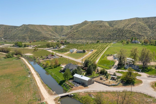 drone / aerial view featuring a rural view and a water and mountain view