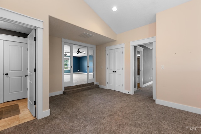 interior space featuring carpet flooring, baseboards, and vaulted ceiling