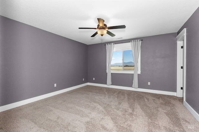 carpeted empty room with baseboards and ceiling fan