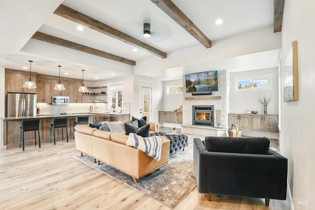 1112 Mos Way, Mccall, ID 83638 - living room featuring light wood-type flooring, recessed lighting, beam ceiling, and a stone fireplace