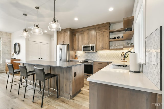 1112 Mos Way, Mccall, ID 83638 - kitchen featuring stainless steel appliances, a sink, backsplash, open shelves, and a breakfast bar area