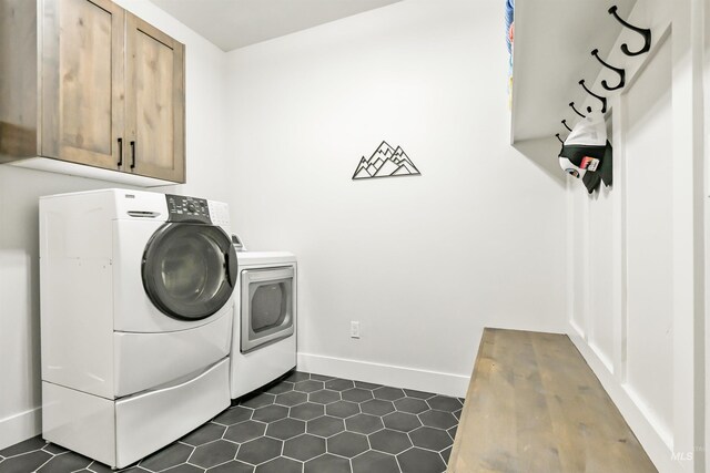 1112 Mos Way, Mccall, ID 83638 - laundry room featuring washer and dryer, cabinet space, dark tile patterned flooring, and baseboards
