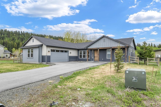 1112 Mos Way, Mccall, ID 83638 - view of front of home featuring a garage, asphalt driveway, roof with shingles, and board and batten siding