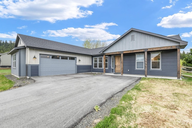 1112 Mos Way, Mccall, ID 83638 - single story home featuring asphalt driveway, an attached garage, roof with shingles, and board and batten siding