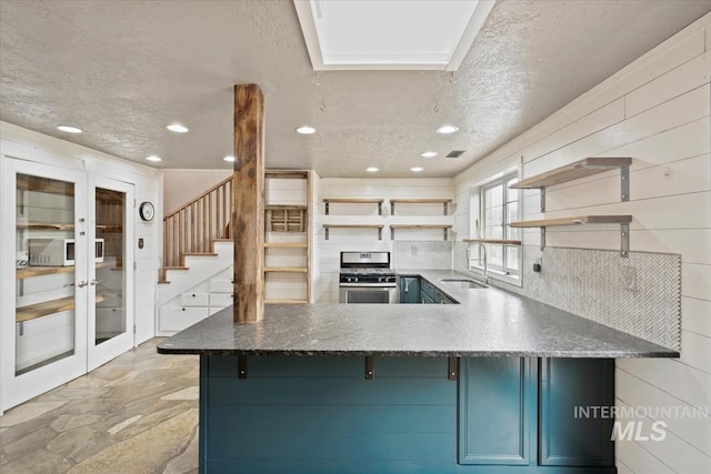 12091 Long St, Middleton, ID 83644 - kitchen with stainless steel range with gas stovetop, open shelves, a sink, blue cabinetry, and a textured ceiling