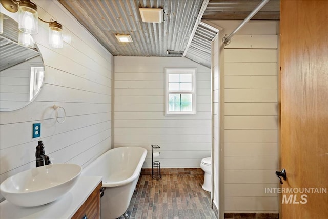 12091 Long St, Middleton, ID 83644 - full bathroom featuring wooden walls, a freestanding tub, vanity, toilet, and a shower