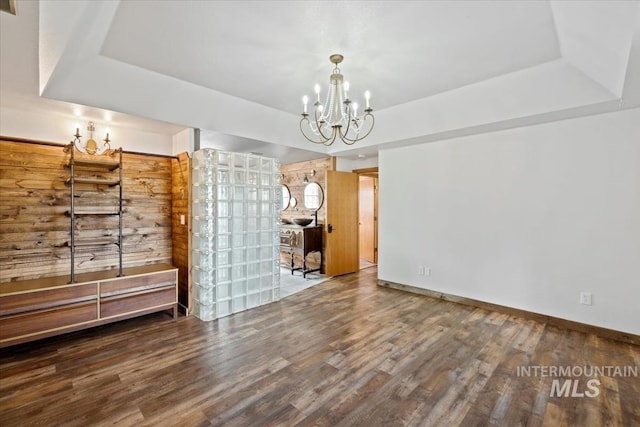 12091 Long St, Middleton, ID 83644 - unfurnished living room with a chandelier, a raised ceiling, wood finished floors, and baseboards