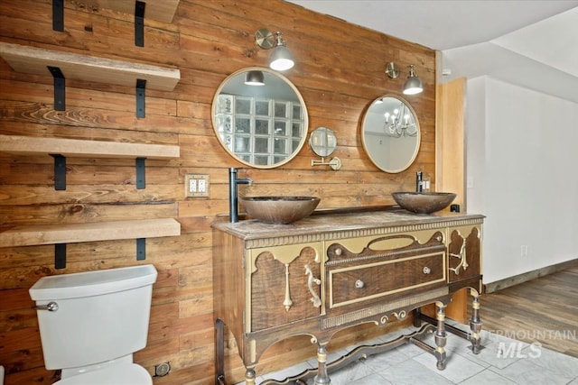12091 Long St, Middleton, ID 83644 - bathroom featuring wood walls, double vanity, toilet, and baseboards