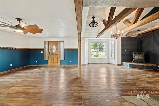 12091 Long St, Middleton, ID 83644 - unfurnished living room featuring wood-type flooring, baseboards, a wood stove, and a chandelier
