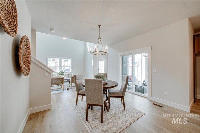 1664 E Cutgrass Ln, Eagle, ID 83616 - dining space featuring a chandelier, light wood-style floors, and baseboards
