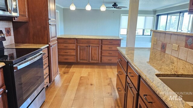 kitchen featuring appliances with stainless steel finishes, crown molding, light wood finished floors, brown cabinets, and hanging light fixtures
