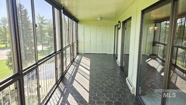 unfurnished sunroom featuring healthy amount of natural light and baseboard heating