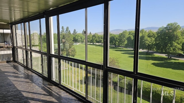 unfurnished sunroom featuring a mountain view and stone finish floors