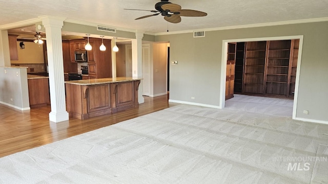 unfurnished living room with ceiling fan, decorative columns, light colored carpet, ornamental molding, and baseboards