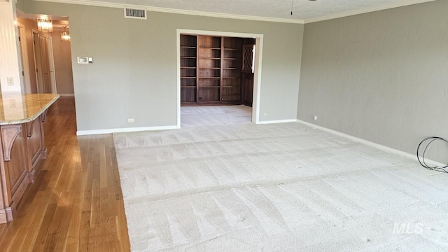 unfurnished room with built in shelves, baseboards, ornamental molding, and a ceiling fan