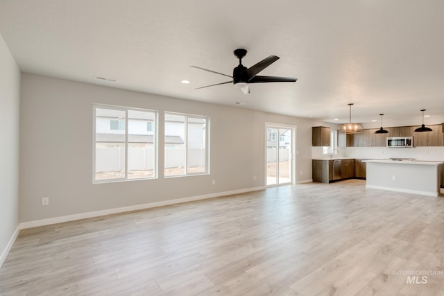 unfurnished living room with recessed lighting, light wood-style flooring, a ceiling fan, and baseboards