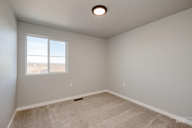 carpeted empty room with visible vents and baseboards