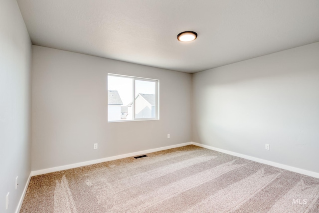 carpeted empty room with visible vents and baseboards