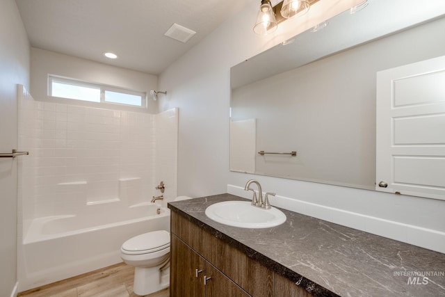 bathroom featuring vanity, wood finished floors, visible vents, shower / tub combination, and toilet