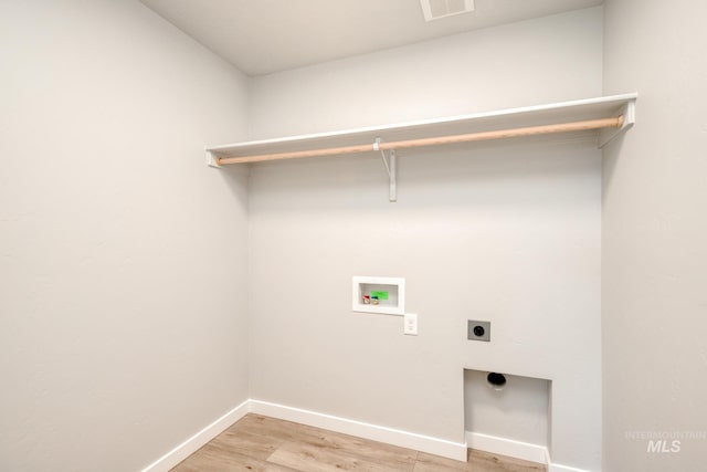 laundry area with baseboards, light wood finished floors, hookup for an electric dryer, laundry area, and washer hookup