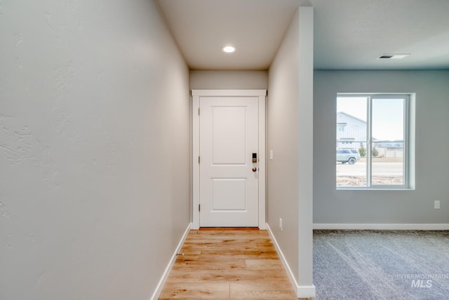 doorway with recessed lighting, light wood-style floors, and baseboards