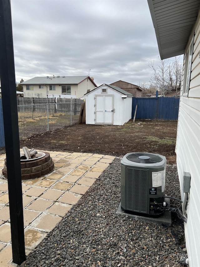 view of patio / terrace with a shed, central AC unit, and an outdoor fire pit